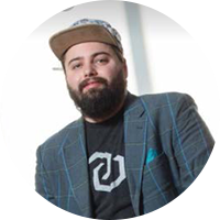 homme d'affaires portant un blazer bleu, un t-shirt graphique et une casquette