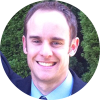 Business man wearing a blue suit with a blue top smiling