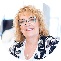 Image of a white business woman with blond hair and wearing glasses smiling